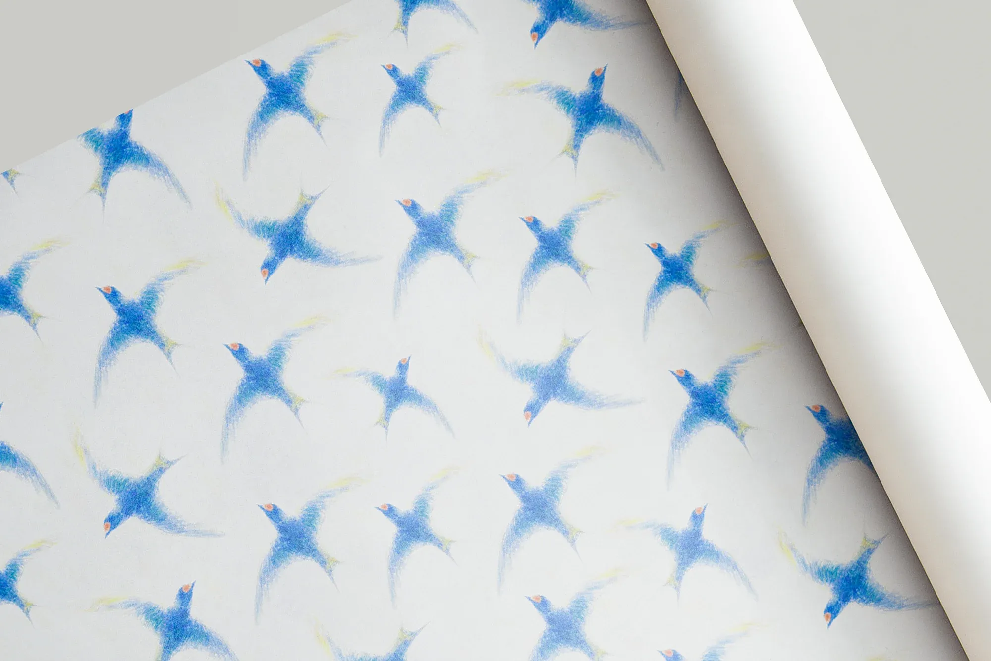 A rolled sheet of white paper printed with an allover pattern of blue swallows in flight.