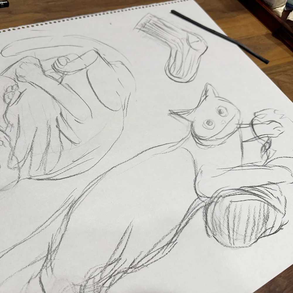 木炭で猫や靴下のスケッチを描いた紙と画材