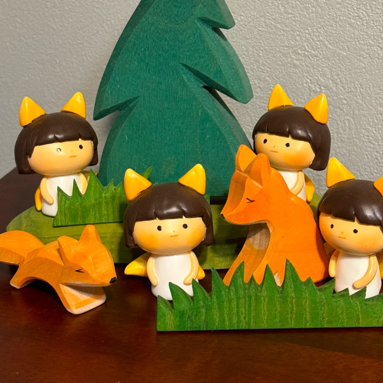 木の置物やきつねの置物と並べて遊ばせている「こんこんわらべ」のフィギュア。